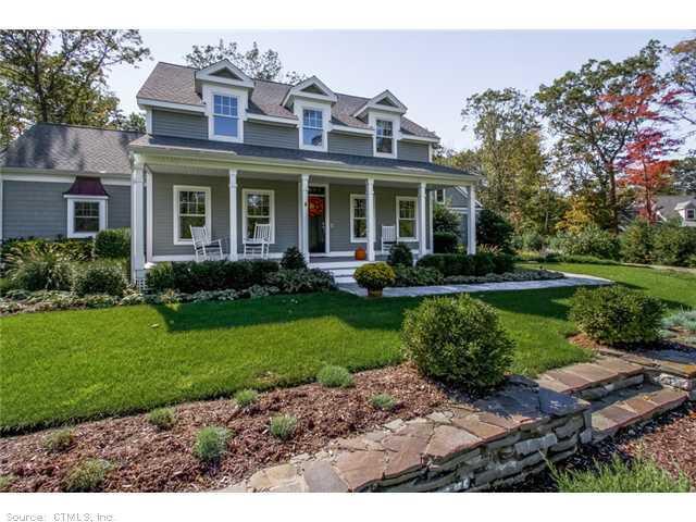 a front view of a house with a yard and potted plants