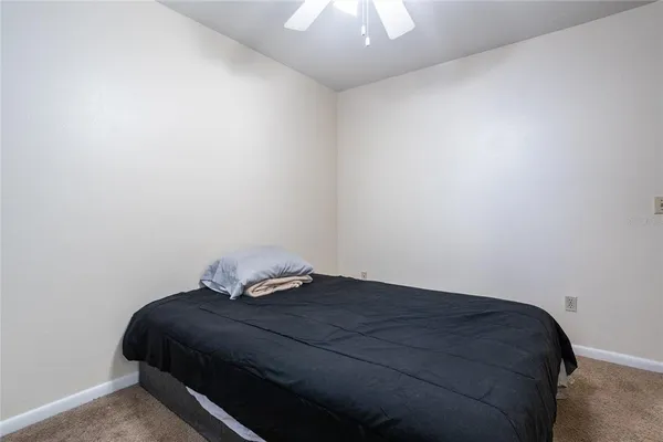 a bedroom with a bed and a chandelier fan