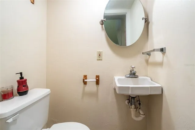 a bathroom with a sink mirror and toilet