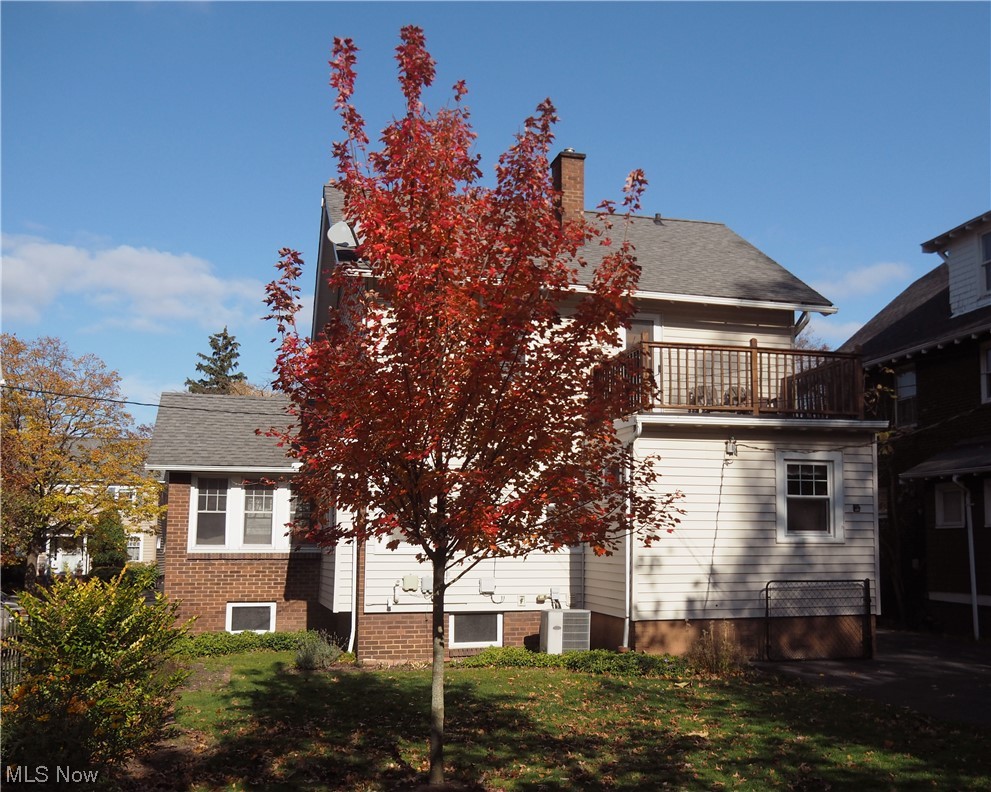 Rear view of house featuring a balcony and central AC unit