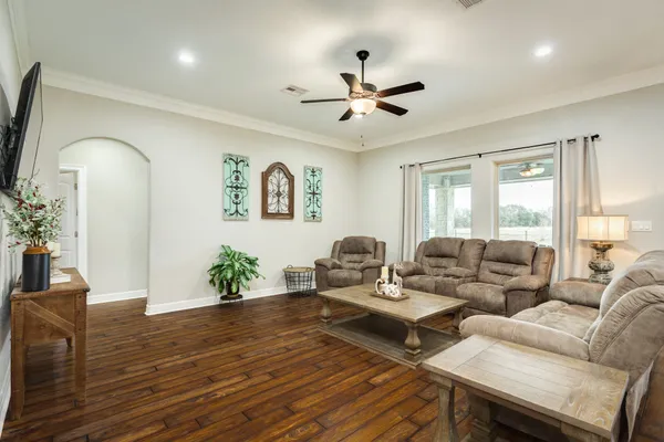 a living room with furniture and a wooden floor