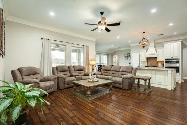 a living room with furniture a flat screen tv and kitchen view