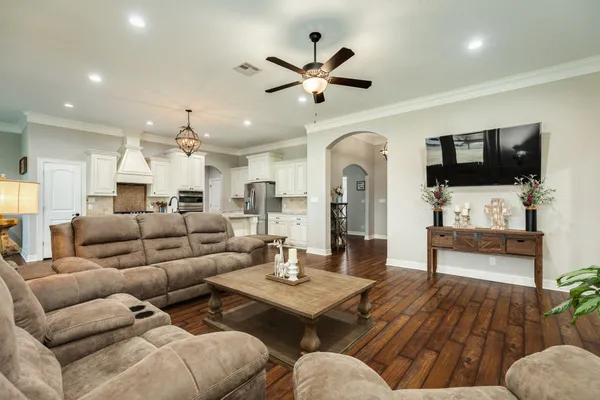 a kitchen with a refrigerator a sink dishwasher a stove and white cabinets with wooden floor