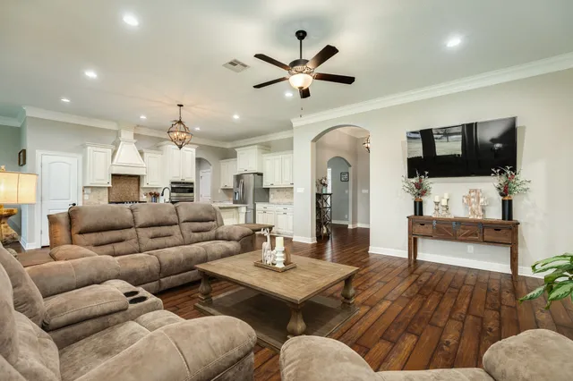 a kitchen with a refrigerator a sink dishwasher a stove and white cabinets with wooden floor