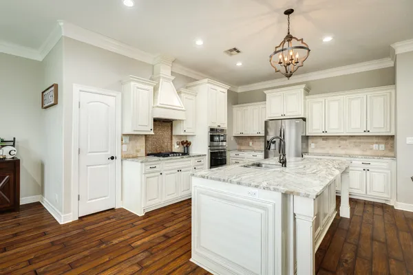 a view of living room kitchen island stainless steel appliances wooden floor and living room view