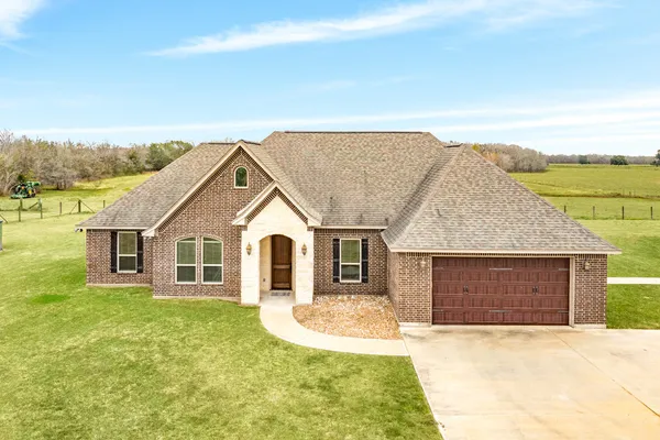 a front view of a house with a garden and yard