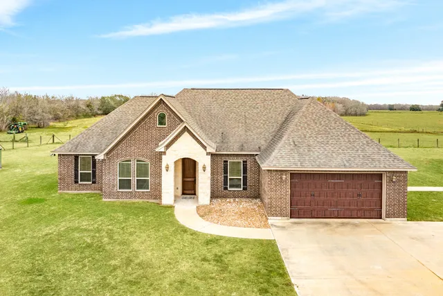 a front view of a house with a garden and yard