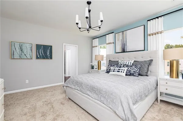 a bedroom with a large bed and a chandelier