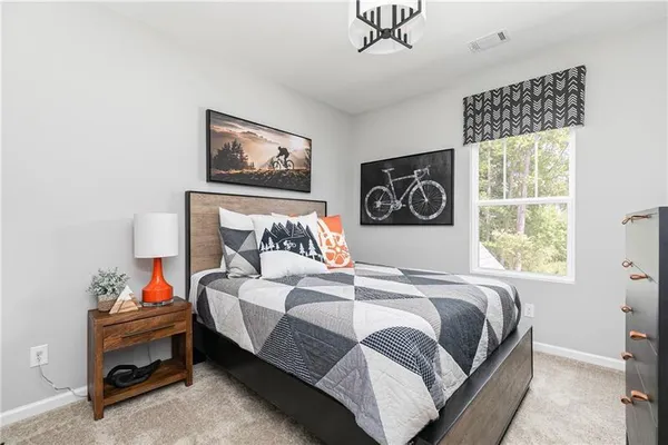 a bedroom with a bed and a painting on the wall