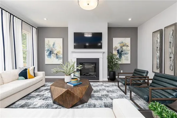 a living room with furniture a flat screen tv and a fireplace