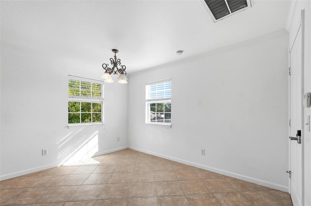 633 Rose Garden Drive, Unit 2 McKinney, TX 75072 - Photo 15 of 17 an empty room with windows and chandelier