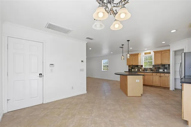 a view of kitchen with granite countertop white cabinets and stainless steel appliances