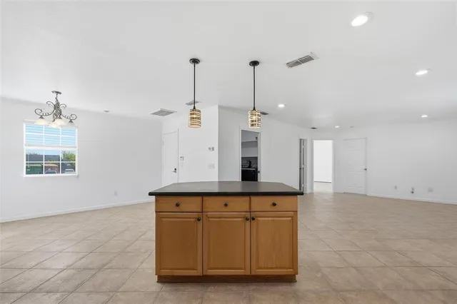 an empty room with windows and chandelier