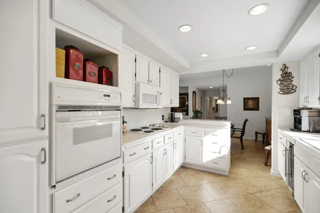 a kitchen with white cabinets and white appliances