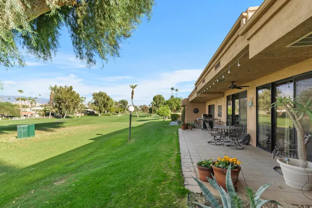 a view of a swimming pool with lawn chairs and a big yard