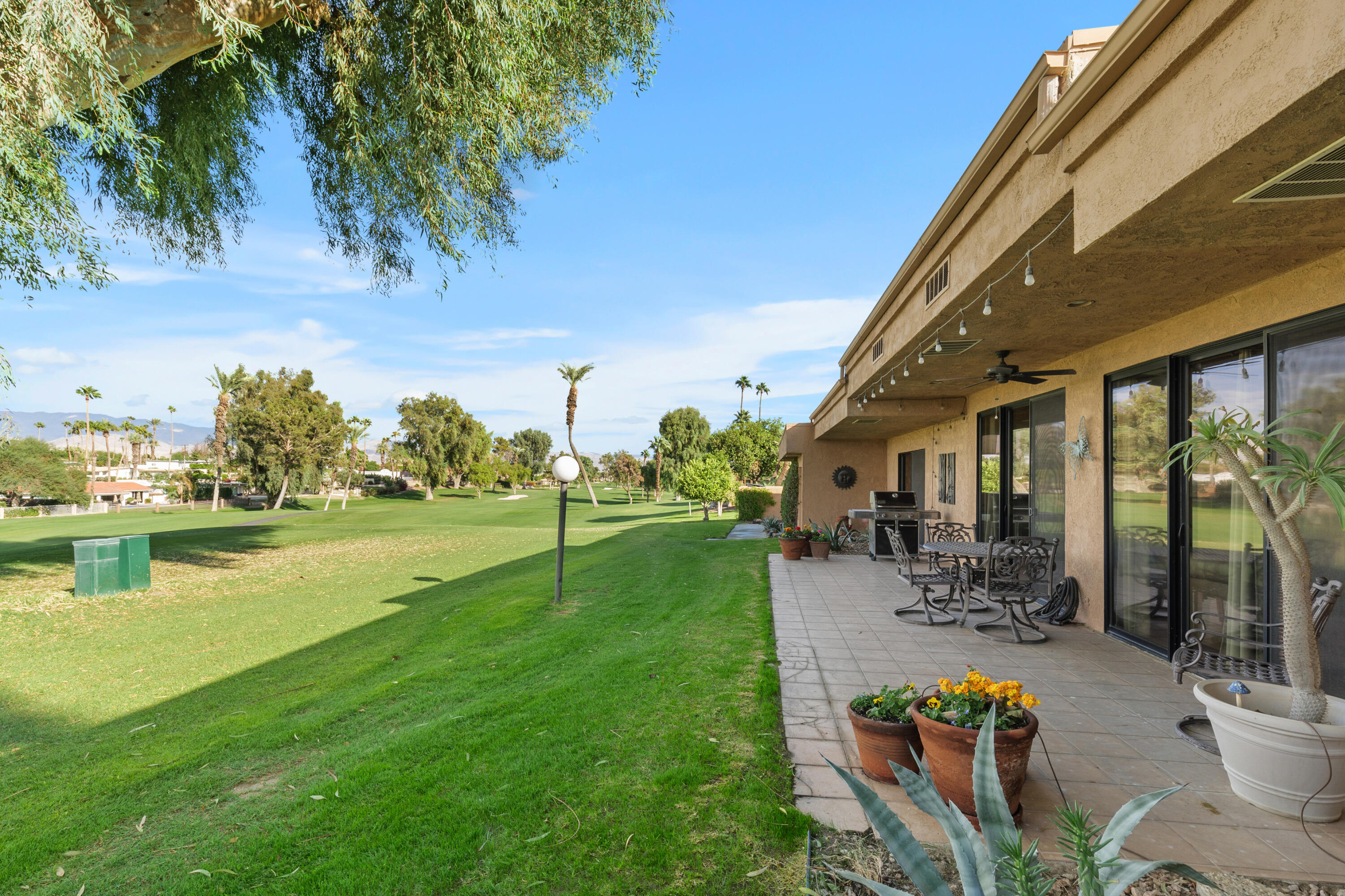 42410 Adams Street Bermuda Dunes, CA 92203 - Photo 33 of 39 a view of a swimming pool with lawn chairs and a big yard