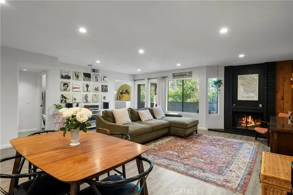 a living room with furniture a fireplace and large window
