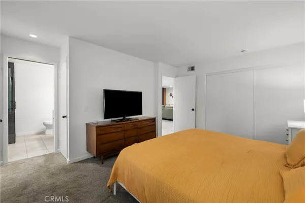 a bedroom with a bed and a flat screen tv