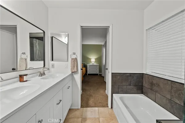 a en suite bathroom with a double vanity sink and a mirror