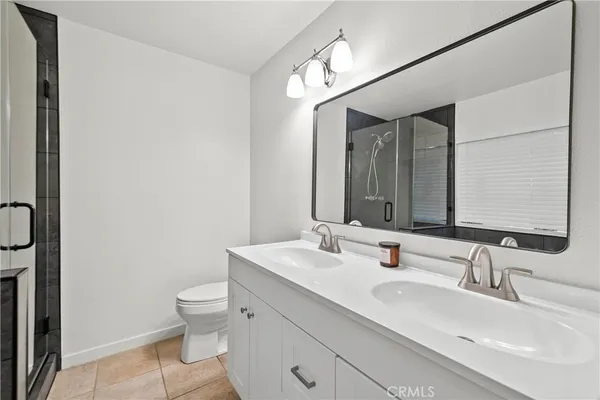a bathroom with a double vanity sink toilet and mirror
