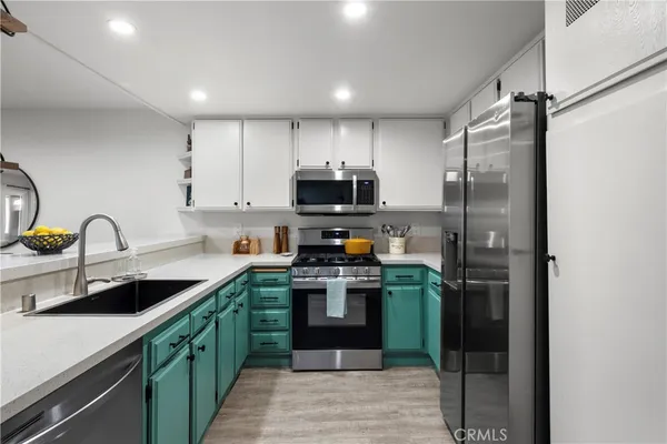a kitchen with stainless steel appliances granite countertop a refrigerator and a sink