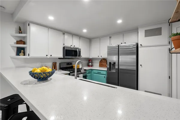 a kitchen with stainless steel appliances a refrigerator a stove a microwave and a sink