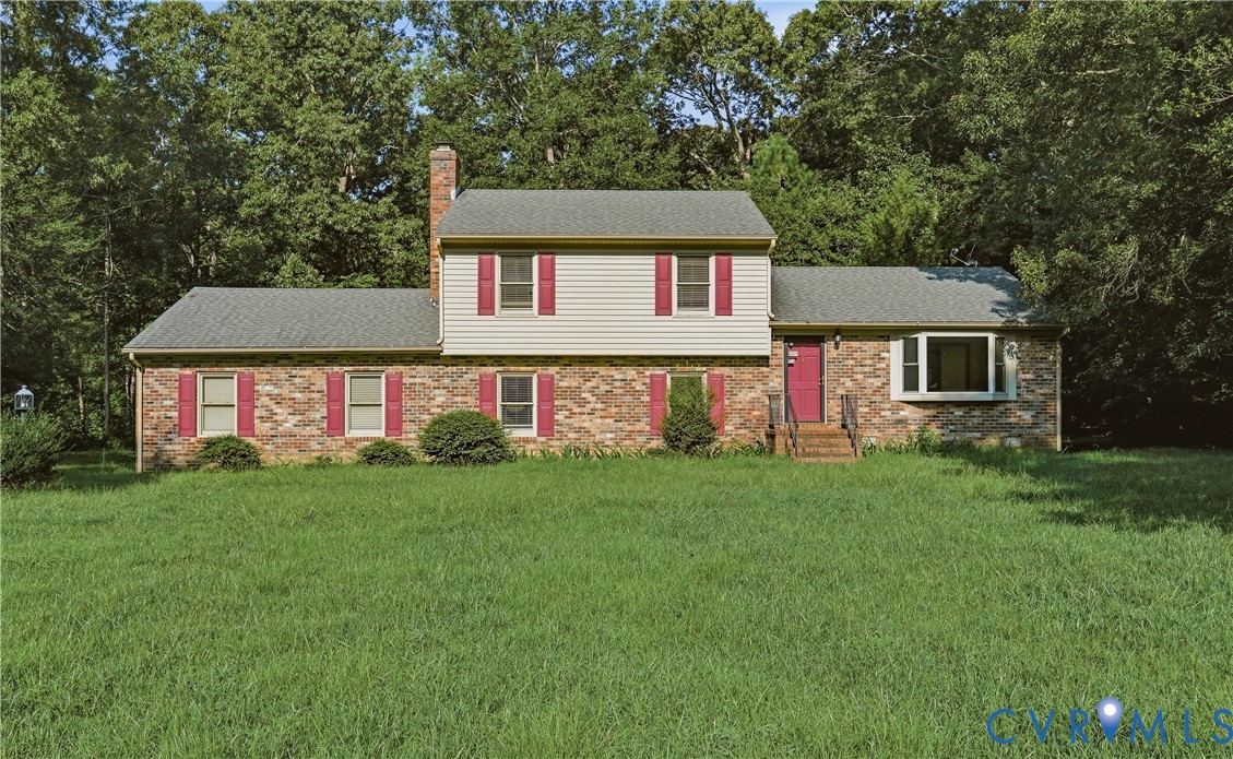 Charming brick Colonial featuring a symmetrical fa