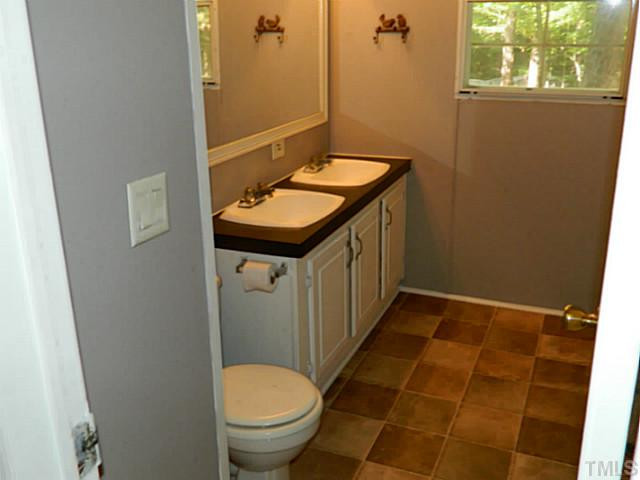 2028 Carpenter Pond Road Raleigh, NC 27613 - Photo 15 of 23 a bathroom with a sink a toilet and a mirror