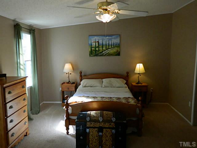 2028 Carpenter Pond Road Raleigh, NC 27613 - Photo 3 of 23 a bedroom with a bed and a chandelier