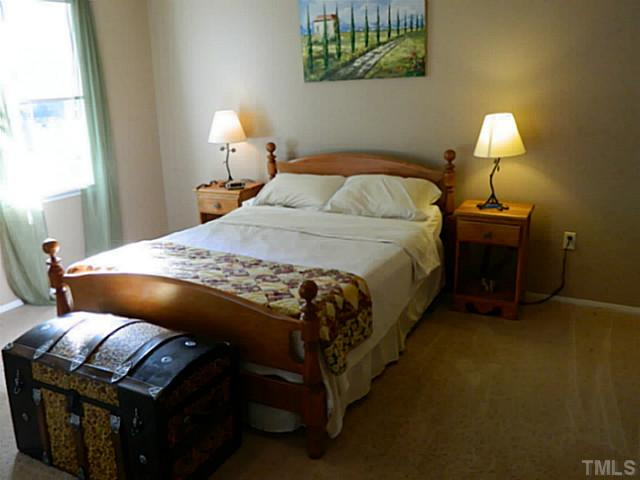 2028 Carpenter Pond Road Raleigh, NC 27613 - Photo 4 of 23 a bedroom with a bed and a lamp