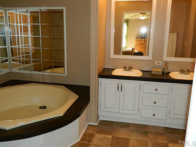 2028 Carpenter Pond Road Raleigh, NC 27613 - Photo 6 of 23 a bathroom with a tub sink and mirror