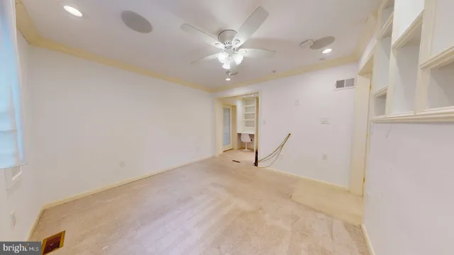 a view of empty room with kitchen and fireplace