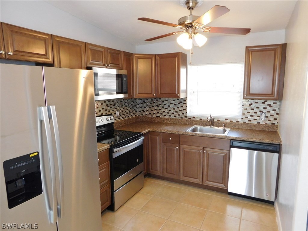 7277 Myrtle Road Fort Myers, FL 33967 - Photo 2 of 17 a kitchen with stainless steel appliances granite countertop a refrigerator and a sink