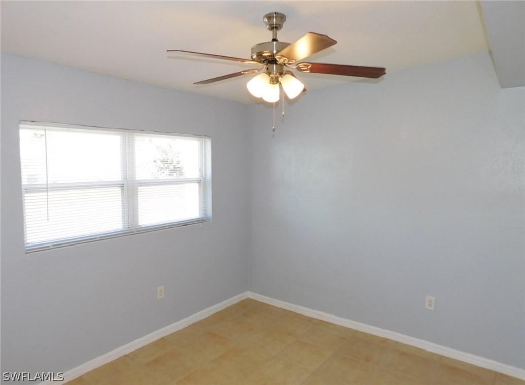 7277 Myrtle Road Fort Myers, FL 33967 - Photo 9 of 17 an empty room with a window and a fan