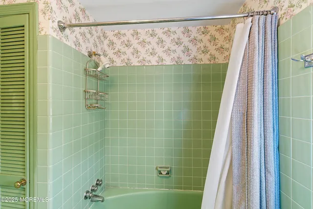 a bedroom with a bed tv and a window