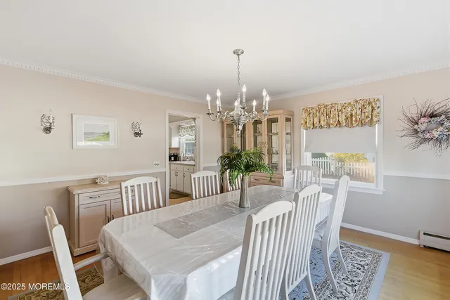 a view of a dining room with furniture a chandelier and wooden floor