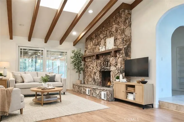 a living room with furniture a flat screen tv and a fireplace