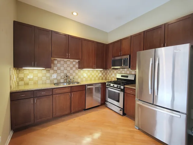 a kitchen with granite countertop stainless steel appliances and wooden cabinets