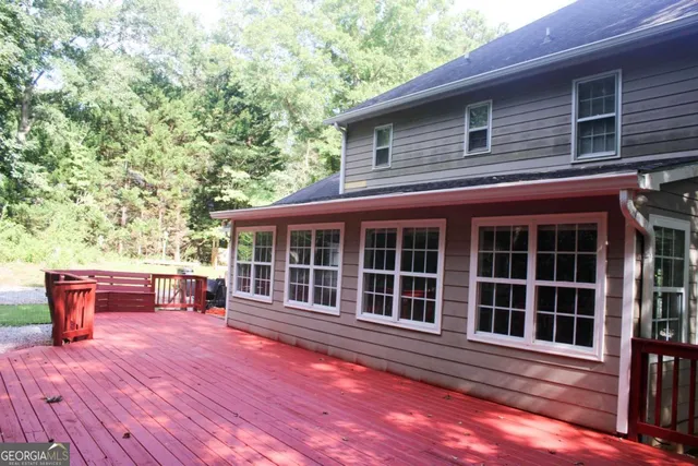 a view of backyard with deck and outdoor seating