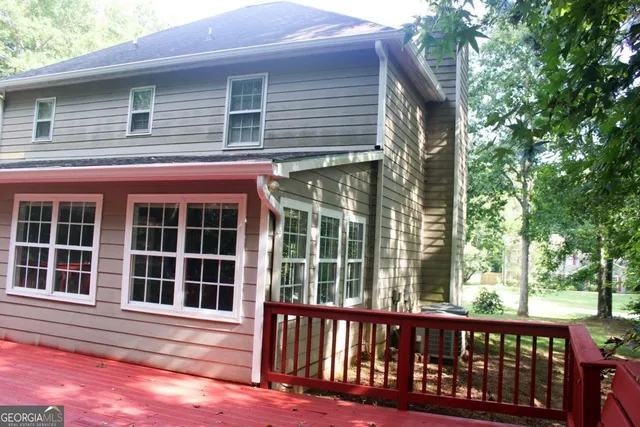 a backyard of a house with lots of plants and large trees