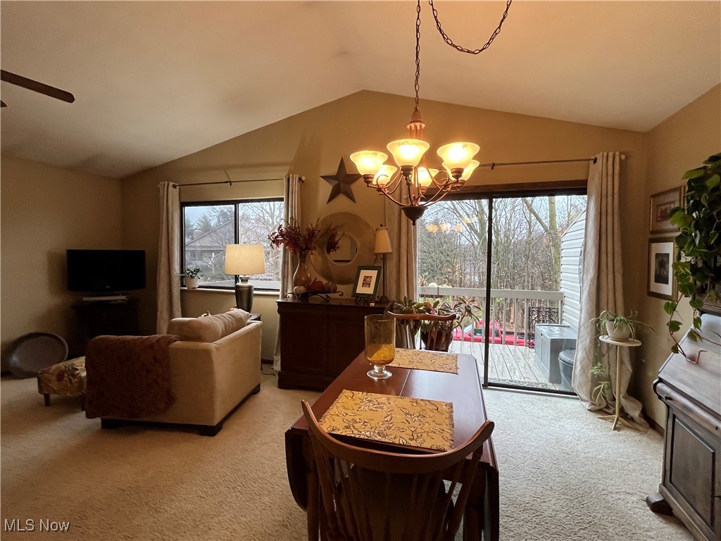 4015 Marks Road, Unit 4B Medina, OH 44256 - Photo 9 of 39 Dining area with ceiling fan with notable chandelier, lofted ceiling, and light colored carpet