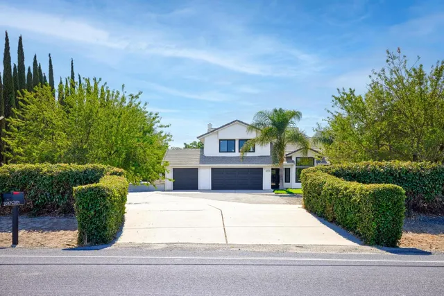a view of a house with a yard and potted plants