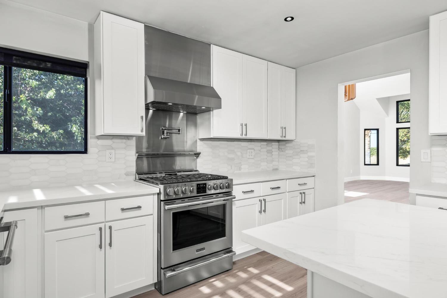 29879 South Chrisman Road Tracy, CA 95304 - Photo 15 of 50 a kitchen with stainless steel appliances a stove and white cabinets