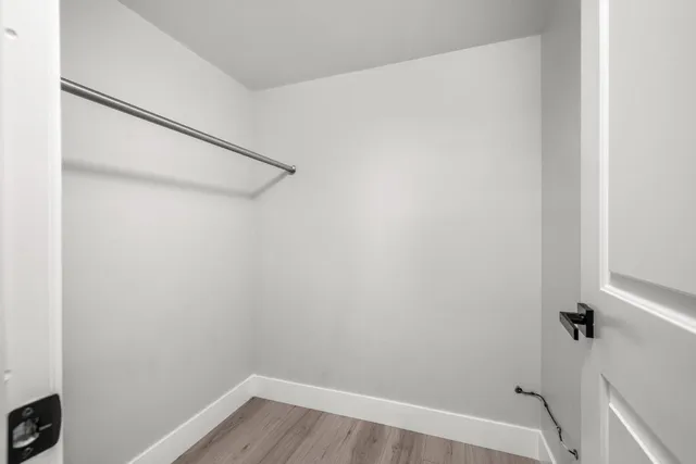 an empty room with closet and a ceiling fan