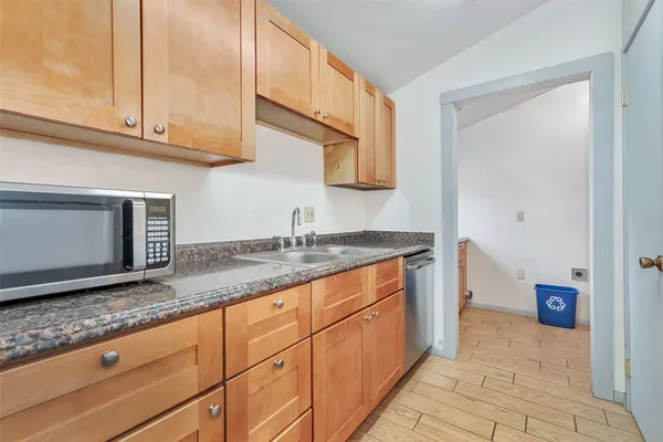 a kitchen with granite countertop a sink and cabinets