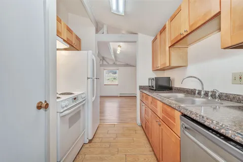 a kitchen with granite countertop a sink and a stove