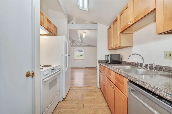 a kitchen with granite countertop a sink and a stove