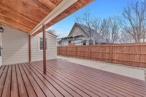 a view of backyard with wooden floor and fence