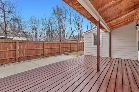 a view of backyard with wooden floor and fence