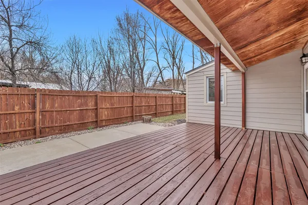 a view of backyard with wooden floor and fence